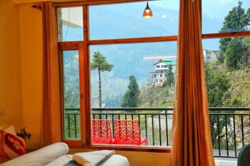 a large window with a view of a mountain view at North star Manali in Vashisht