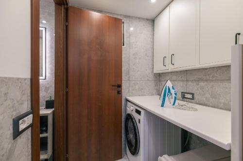 a kitchen with a washing machine and a wooden door at Casa Santari in Parzanica