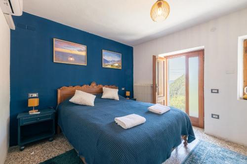 a blue bedroom with a bed with two towels on it at Casa Santari in Parzanica