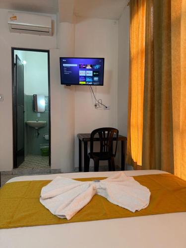 a bedroom with a bed with two white towels on it at Hotel SR, Villa Garzón in Villagarzón