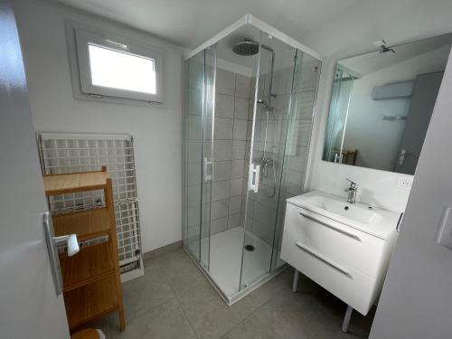 a bathroom with a glass shower and a sink at Le Clos des Genets in Quend