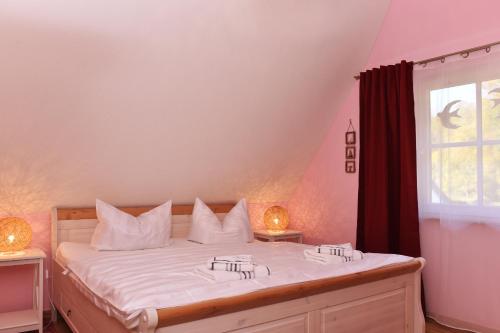 a bedroom with a bed with white sheets and a window at Boddenkieker in Born