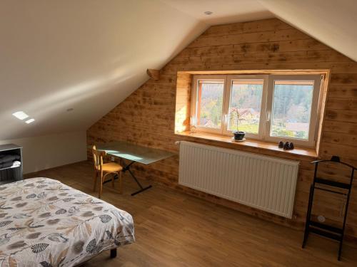 a bedroom with a bed and a window and a desk at Gîte au pied du Mont in Saint-Maurice-sur-Moselle