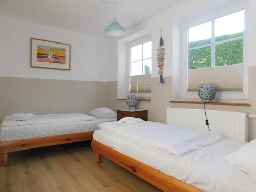 two beds in a room with two windows at Ferienhaus La Mer in Ahrenshoop