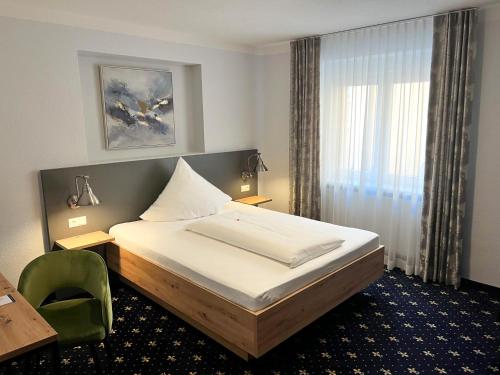 a bedroom with a bed and a desk and a chair at stadthotel miya in Bad Mergentheim