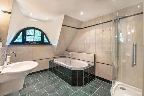 a bathroom with a sink and a tub and a shower at Strandhaus Ahrensh 1 in Ahrenshoop