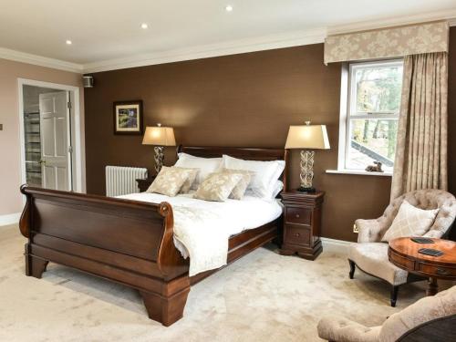 a bedroom with a bed and a chair and a window at 6 Bed in Otley oc-g0022 in Fewston