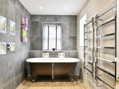 a bathroom with a large tub and a window at 6 Bed in Otley oc-g0022 in Fewston