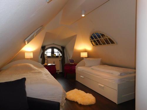 a attic bedroom with two beds and a window at Boje Haus Sanddorn in Althagen