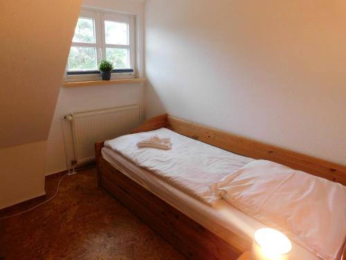 a small bed in a room with a window at Malergarten 14 in Ahrenshoop