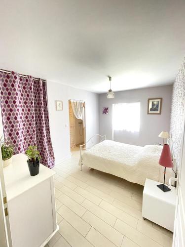 a bedroom with a bed and a window at La maison de La Combe in Parzac