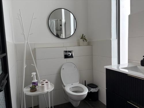 a white bathroom with a toilet and a mirror at Aharon boutique suite in Pardes H̱anna