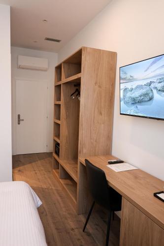 a room with a desk and a bedroom with a bed at Zoe Boutique Hotel in Durrës