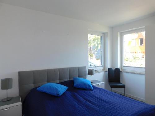 a bedroom with a blue bed with two blue pillows at Sanddornhus in Ahrenshoop