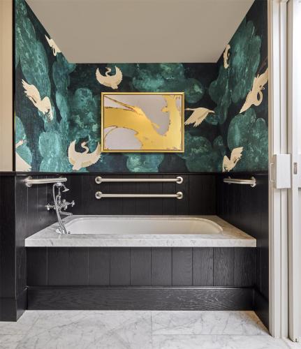 a bathroom with a bath tub with a painting on the wall at Cameo Beverly Hills, LXR Hotels & Resorts in Los Angeles