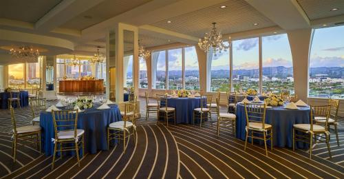 a banquet hall with blue tables and chairs and windows at Cameo Beverly Hills, LXR Hotels & Resorts in Los Angeles
