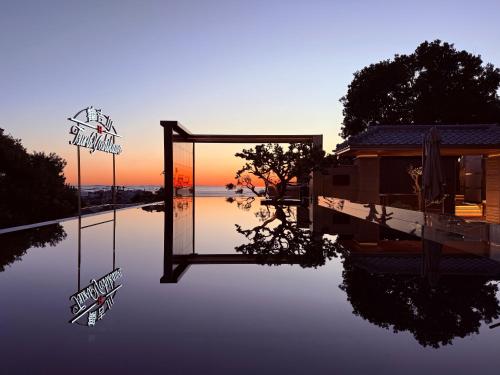 a pool of water with a sign in front of a building at Tsuru Yoshikawa Onsen in Manazuru
