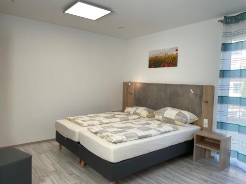 a bedroom with a bed with a wooden headboard at Schäfer Apartments in Oberderdingen
