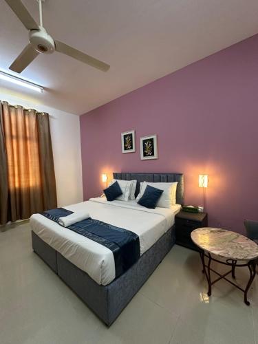 a bedroom with a large bed with purple walls at Savoy Inn Hotel Apartments in Muscat