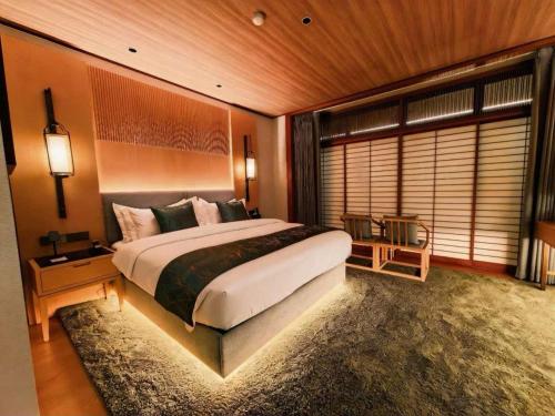 a bedroom with a large bed and a large window at Tsuru Yoshikawa Onsen in Manazuru