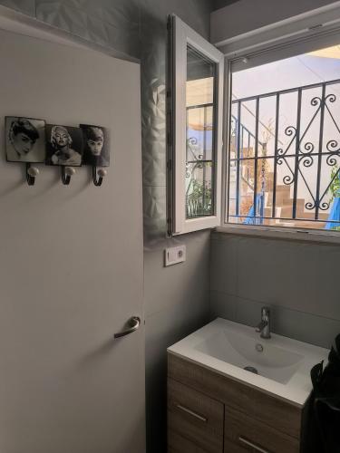 ein Badezimmer mit Waschbecken und Fenster in der Unterkunft La Camera in Camas