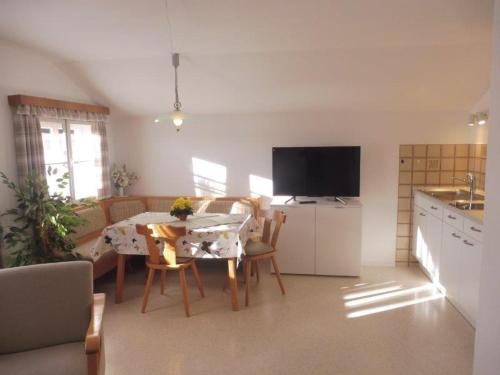 a kitchen and living room with a table and a television at Ferienwohnungen Wennesz in Chieming