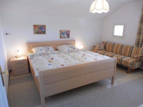 a bedroom with a large bed and a couch at Ferienwohnungen Wennesz in Chieming