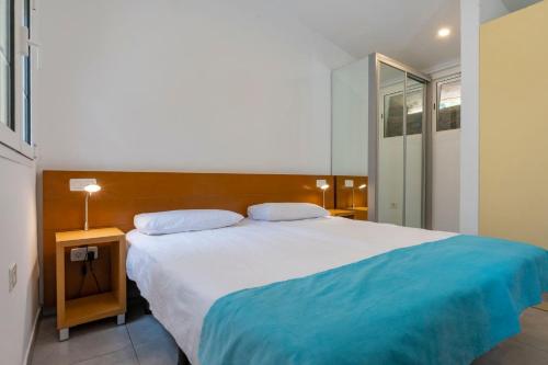 a bedroom with a large bed with a blue blanket at GC0284 El Granero in Mogán