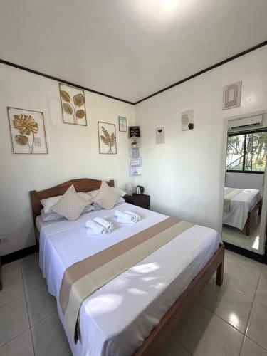 a bedroom with a large bed with white sheets at Zara's Casa Rental in Siquijor