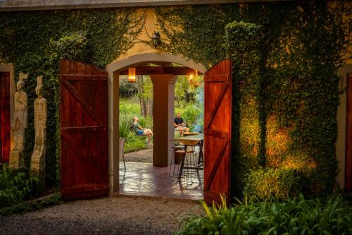 an entrance to a garden with an open door at The River Villa in Magaliesburg