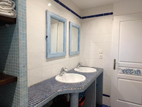 a bathroom with two sinks and two mirrors at La bastide 4 chambres in Artignosc-sur-Verdon