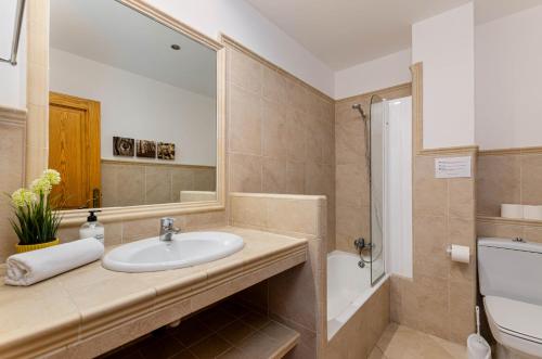 a bathroom with a sink and a mirror and a toilet at YourHouse Casa Rafael in Can Picafort