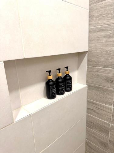 three black bottles sitting on a shelf in a bathroom at Luxury Penthouse, Pool, Bbq, Private Terrace in Pueblo Bavaro