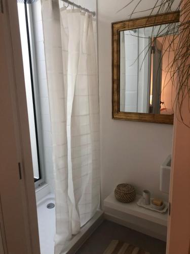 a bathroom with a white shower curtain and a mirror at Maré do Bairro Studio Beira Mar Aveiro in Aveiro