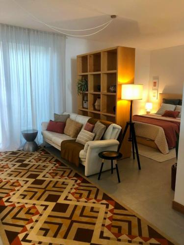 a living room with a couch and a bed at Maré do Bairro Studio Beira Mar Aveiro in Aveiro