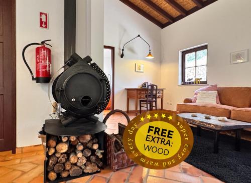 a wood stove in a living room with a sign at Milharadas - A Private Oasis in the Alentejo in Odemira