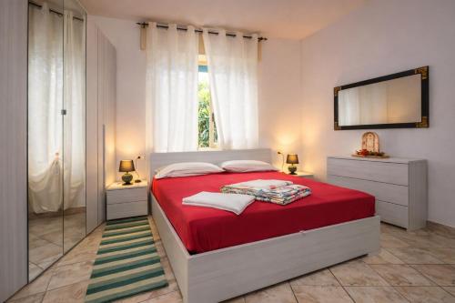 a bedroom with a red bed and a television at Casa Curti 1 in Sorico