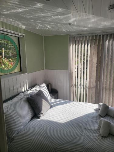 a bedroom with a bed and a window at Lady Lily Spring Unique River Boat with Castle views in Allington