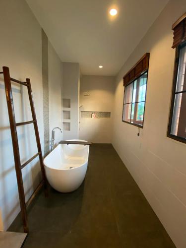 a large white bath tub in a bathroom with a window at Baan Yaimai Boutique Samui in Bophut