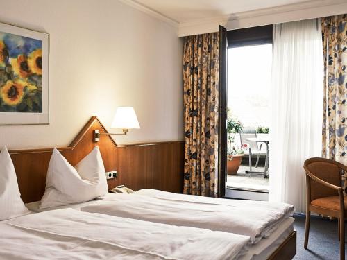 a hotel room with a bed and a window at DORMERO Hotel Crailsheim in Crailsheim