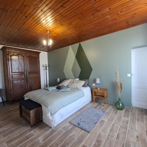 a bedroom with a bed and a wooden ceiling at Joli Eden in Saint-Sulpice-de-Faleyrens