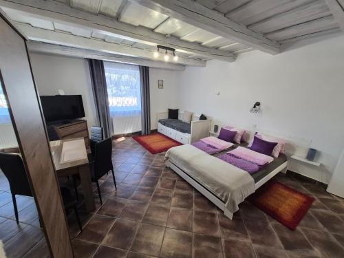 a bedroom with a bed and a desk and a television at Harmony Vendégház Egerszalók in Egerszalók