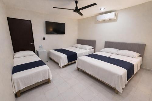 a hotel room with two beds and a tv at Estudios Bacalar in Bacalar