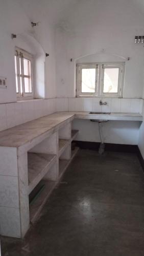 a large wooden table in a room with a sink at Saraswati Kunj in mayapur