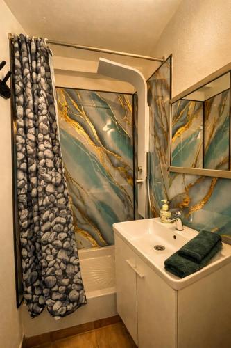 a bathroom with a sink and a shower curtain at Green Haven - Joli studio - Centre Ville de Caen in Caen