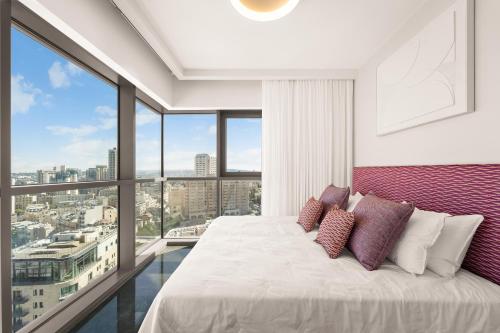 a bedroom with a bed and a large window at Savyon View Tower - Isrentals in Jerusalem