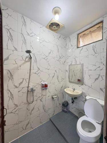 a bathroom with a toilet and a sink at Hotel Ompu Herti in Balige