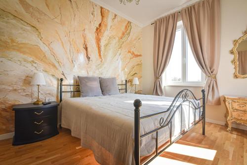 a bedroom with a bed and a stone wall at Lovran deluxe apartman in Lovran