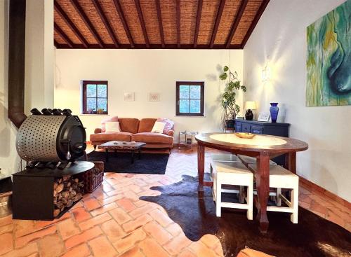 a living room with a table and a fireplace at Milharadas - A Private Oasis in the Alentejo in Odemira
