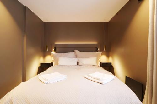 a bedroom with a bed with two towels on it at Arctic City Suites 2 in Kirkenes